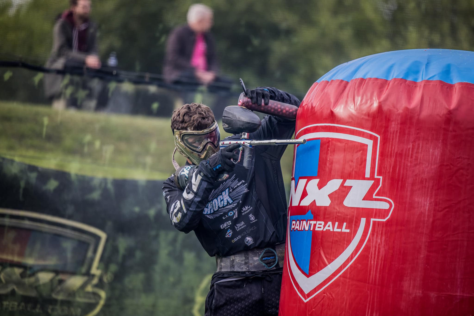 Paintball-Spieler hinter Deckung im laufenden Match